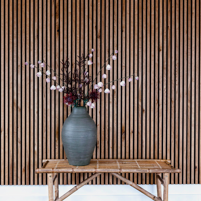 Stor vase med blomster på bambusbænk